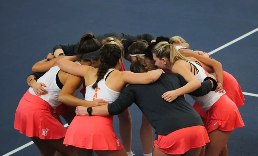 College tennis team hugging each other