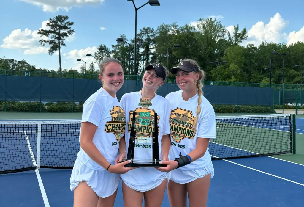Linn Goerdes raising the Conference Championship trophy with her teammates