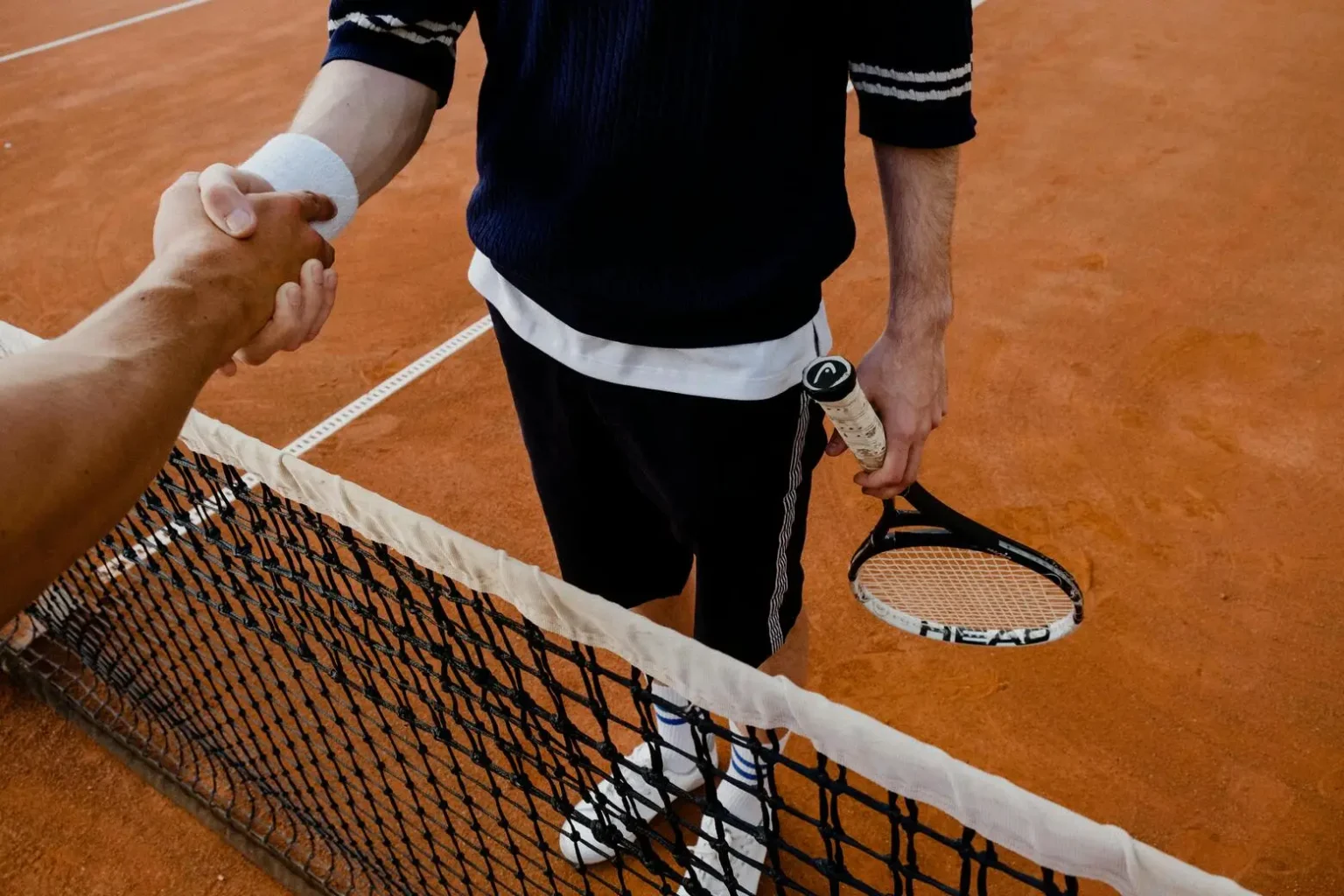 shaking hands over tennis net