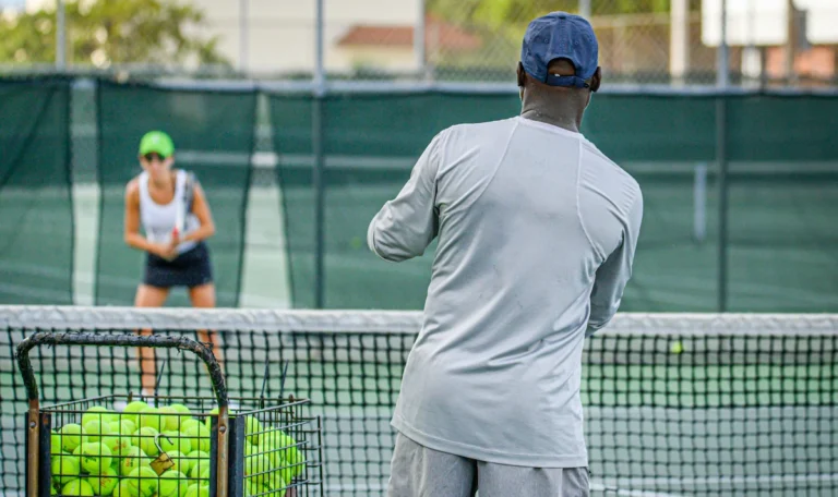 Tennis coach and player during practice.