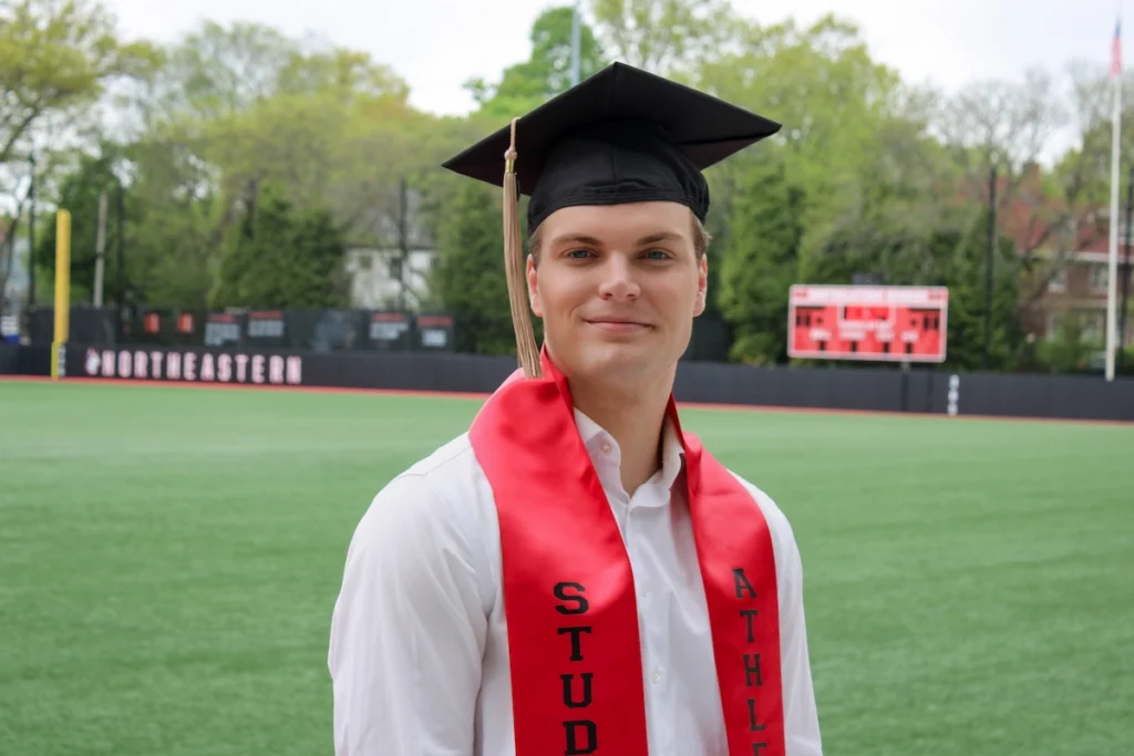 Student-athlete Tobias Wangerud posing in his cap and gown for graduation photos.