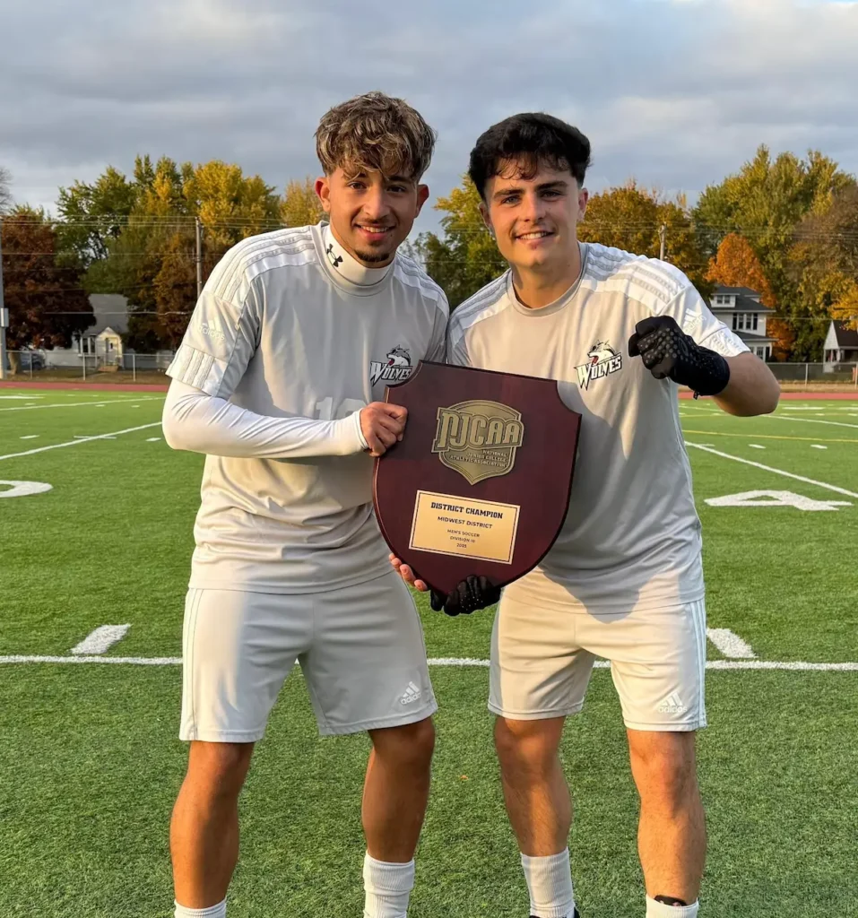 Francisco Sanches do Nascimento and his teammate posing with the title