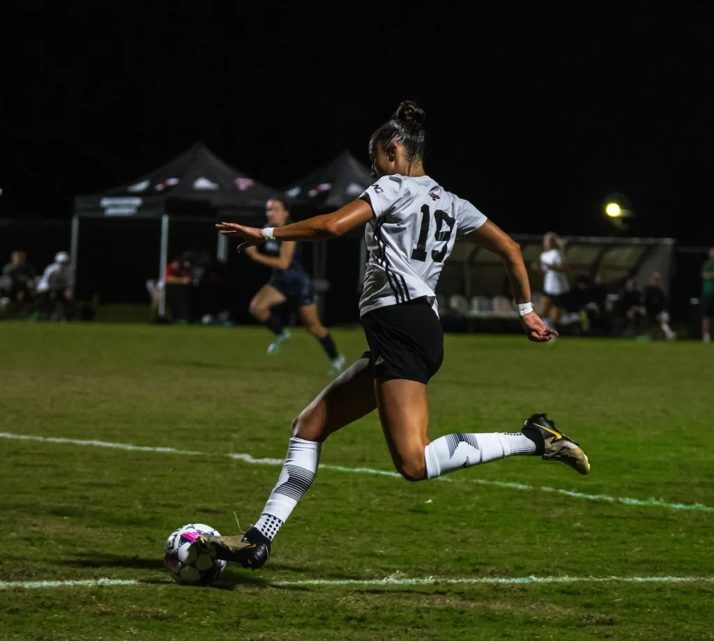 College soccer player, Sara Irurozki, dribbling the ball in a game