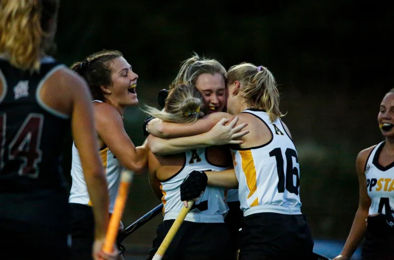 Female field hockey players celebrating
